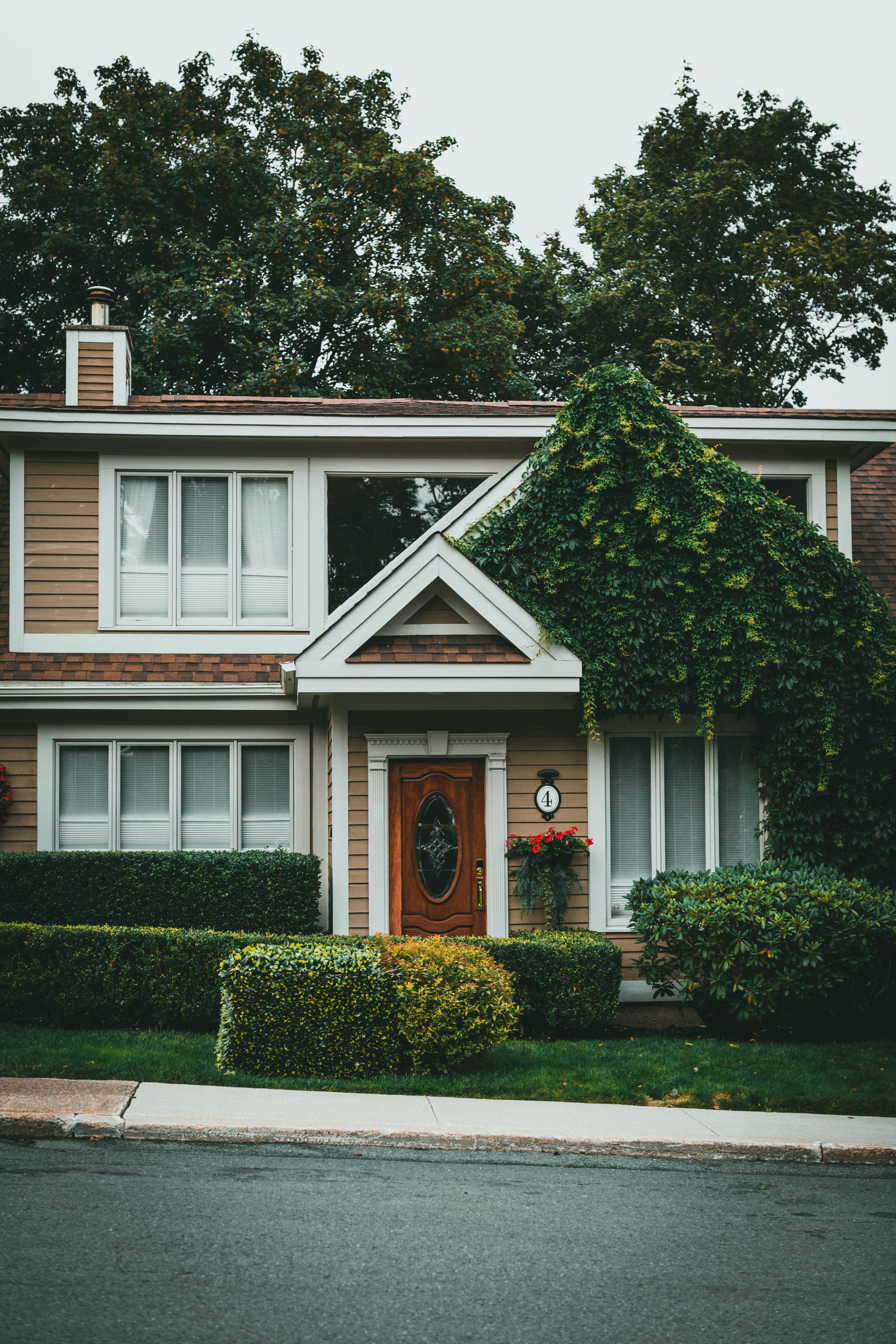 Casa de madera blanca y marrón cerca de árboles verdes durante el día.